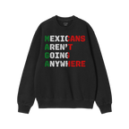 Black crew-neck sweatshirt featuring “Mexicans Aren’t Going Anywhere” in Mexican flag colors, with MAGA highlighted in 