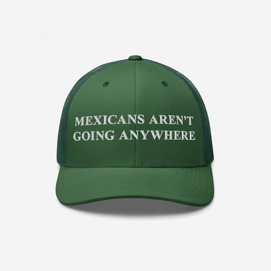 Mexicans Aren’t Going Anywhere Hat: A green trucker-style cap with a white embroidered message promoting pride and resistance, featuring a mesh back for breathability and a bold statement against racism.