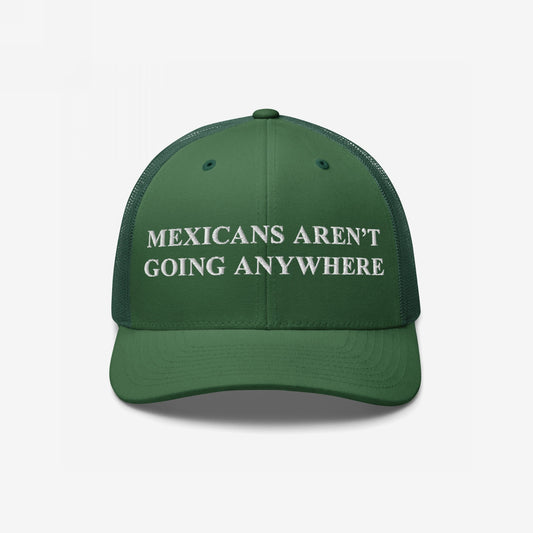 Mexicans Aren’t Going Anywhere Hat: A green trucker-style cap with a white embroidered message promoting pride and resistance, featuring a mesh back for breathability and a bold statement against racism.