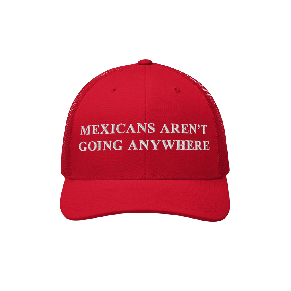 The Mexicans Aren’t Going Anywhere Hat showcases a bold statement with white embroidery on a red trucker cap, featuring a m