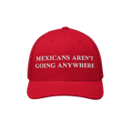 The Mexicans Aren’t Going Anywhere Hat showcases a bold statement with white embroidery on a red trucker cap, featuring a m