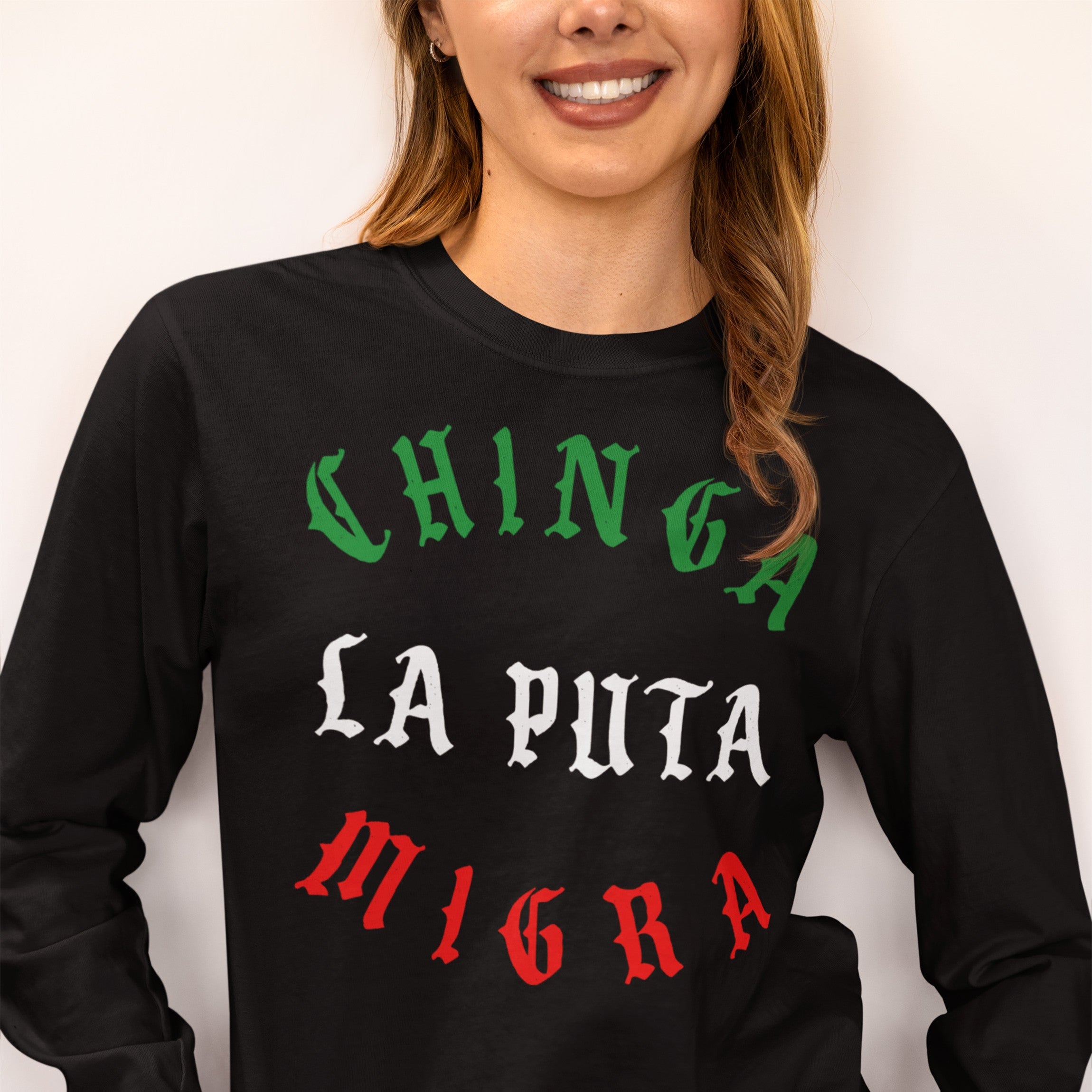 Person wearing a Chinga La Migra Mexico T-shirt, featuring bold Old English–style text in Mexican flag colors, conveying a strong anti-immigration authority message on a black long-sleeve shirt.