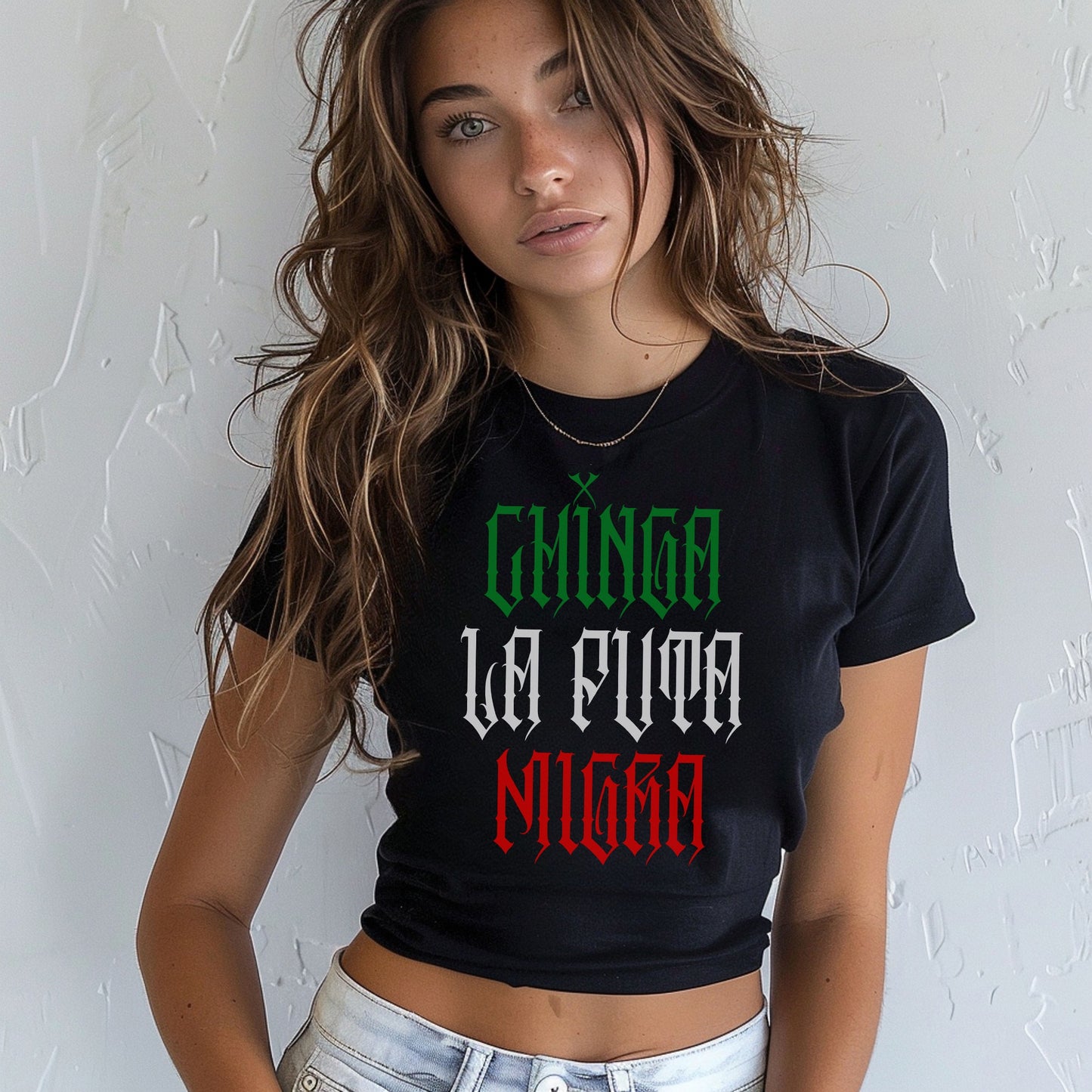 Young woman models the Chinga La Migra Mexico Women's Baby Tee, a black crop-top featuring bold Gothic-style text, embodying protest and identity with a Y2K fit and tricolor Mexican flag design.