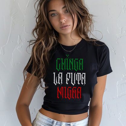 Young woman models the Chinga La Migra Mexico Women's Baby Tee, a black crop-top featuring bold Gothic-style text, embodying protest and identity with a Y2K fit and tricolor Mexican flag design.