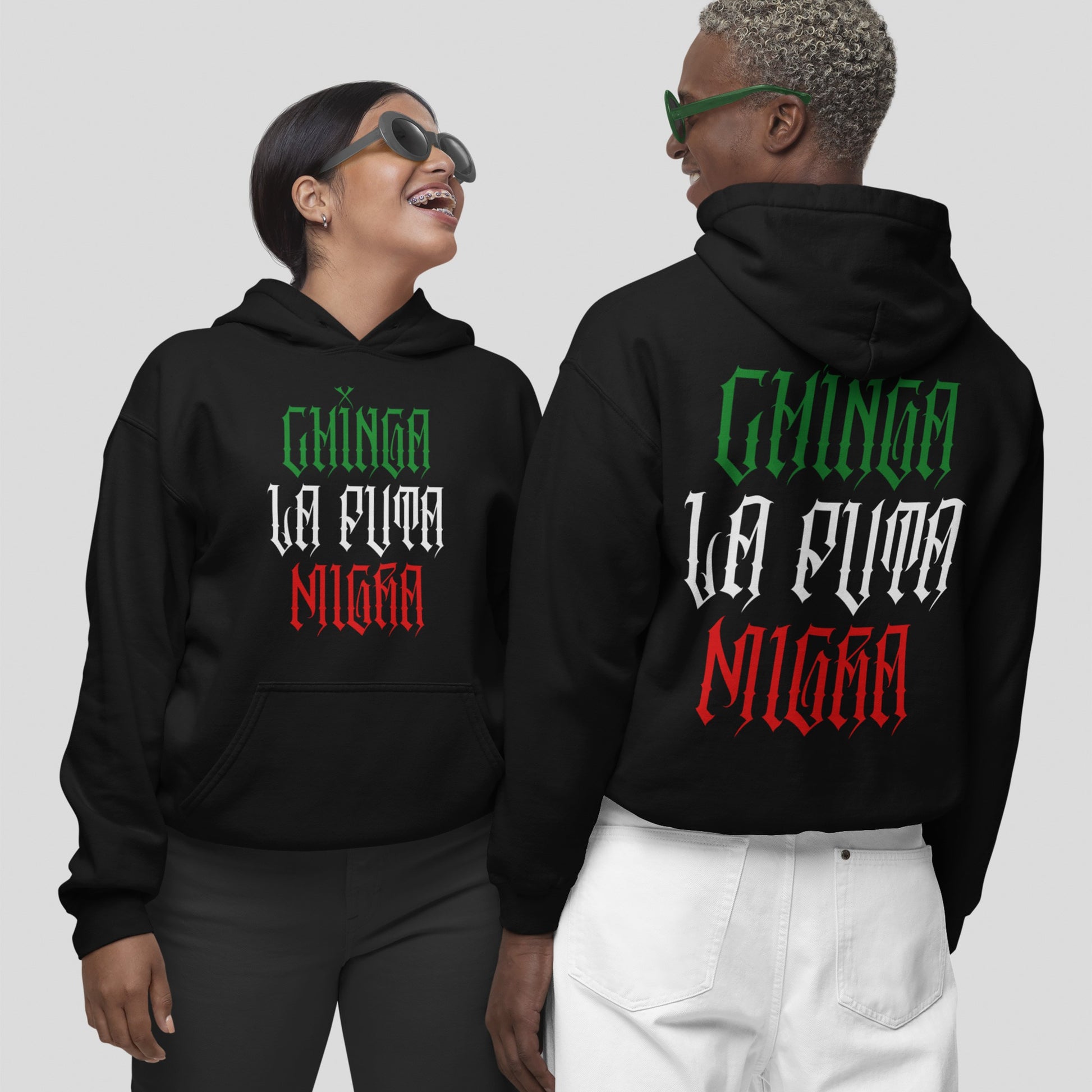 Two models showcase the Chinga La Migra Mexico Hoodie, featuring a bold, gothic-style slogan in Mexican flag colors on both front and back, embodying a spirit of defiance and pride.