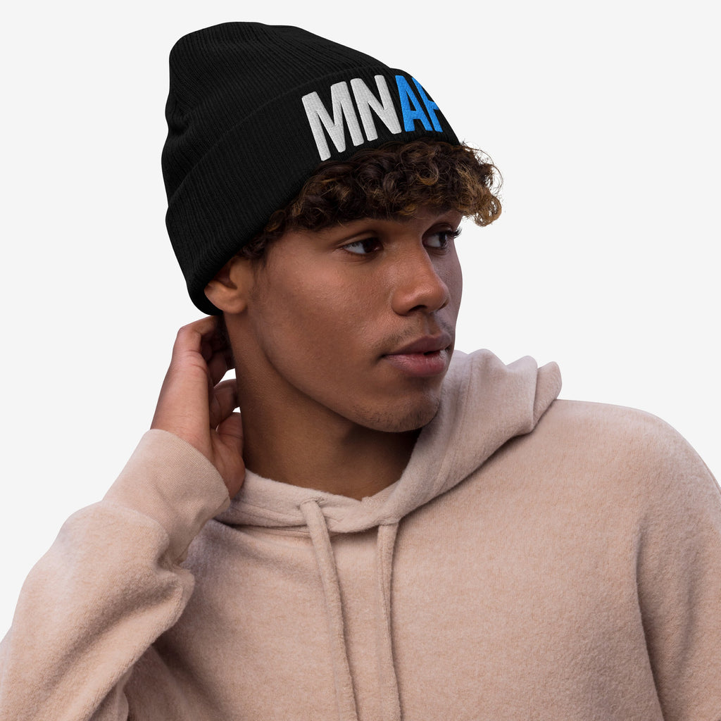 Young man in a light-beige hoodie wearing a black knit beanie with MNAR embroidered, embodying the Minnesota As Fuck Anti-Fascist Hat, symbolizing pro-equality and anti-fascist energy.