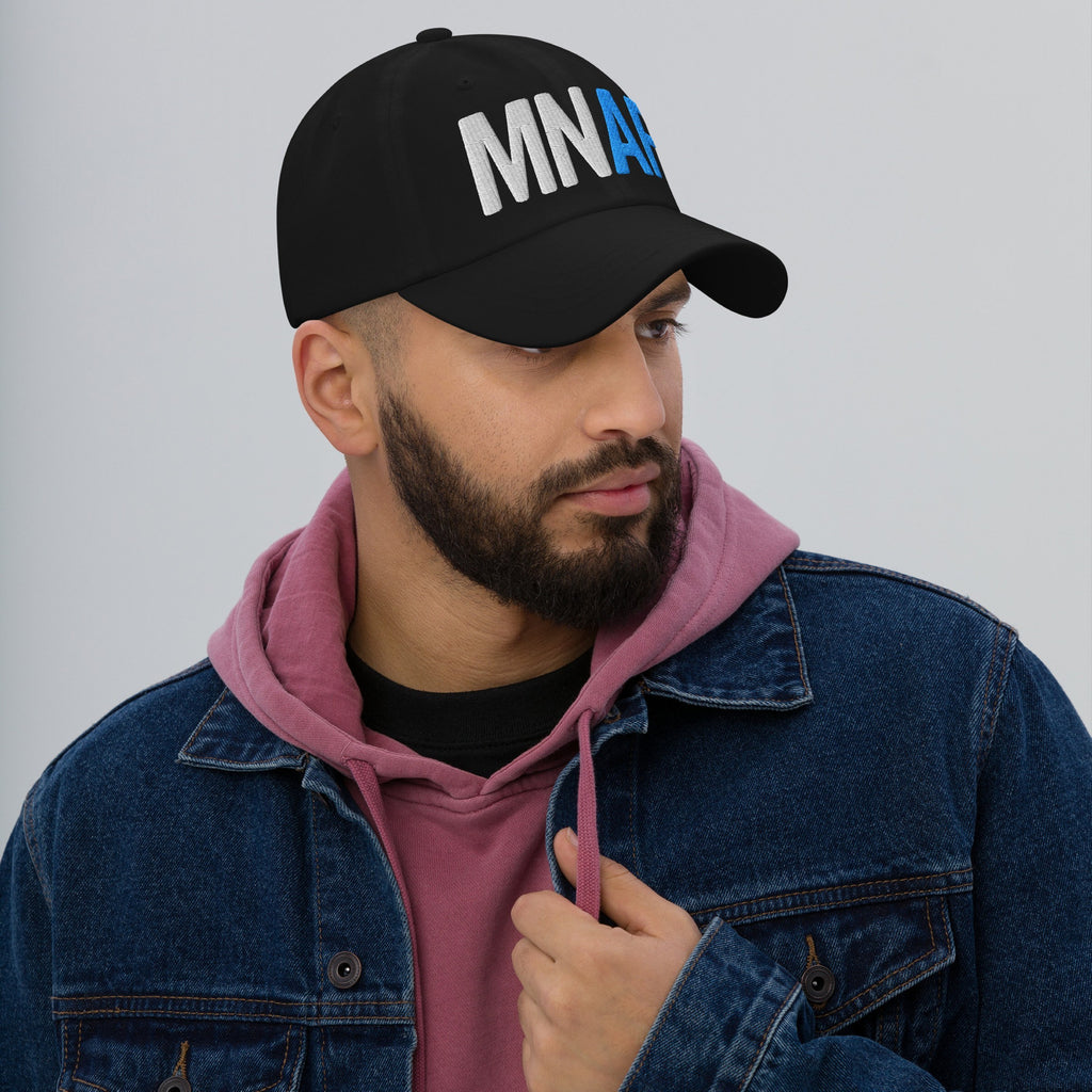 Minnesota As Fuck Anti-Fascist Hat on a young man, styled with a black cap featuring bold white and blue embroidery, paired with a rose-pink hoodie and denim jacket, embodying pro-equality spirit.
