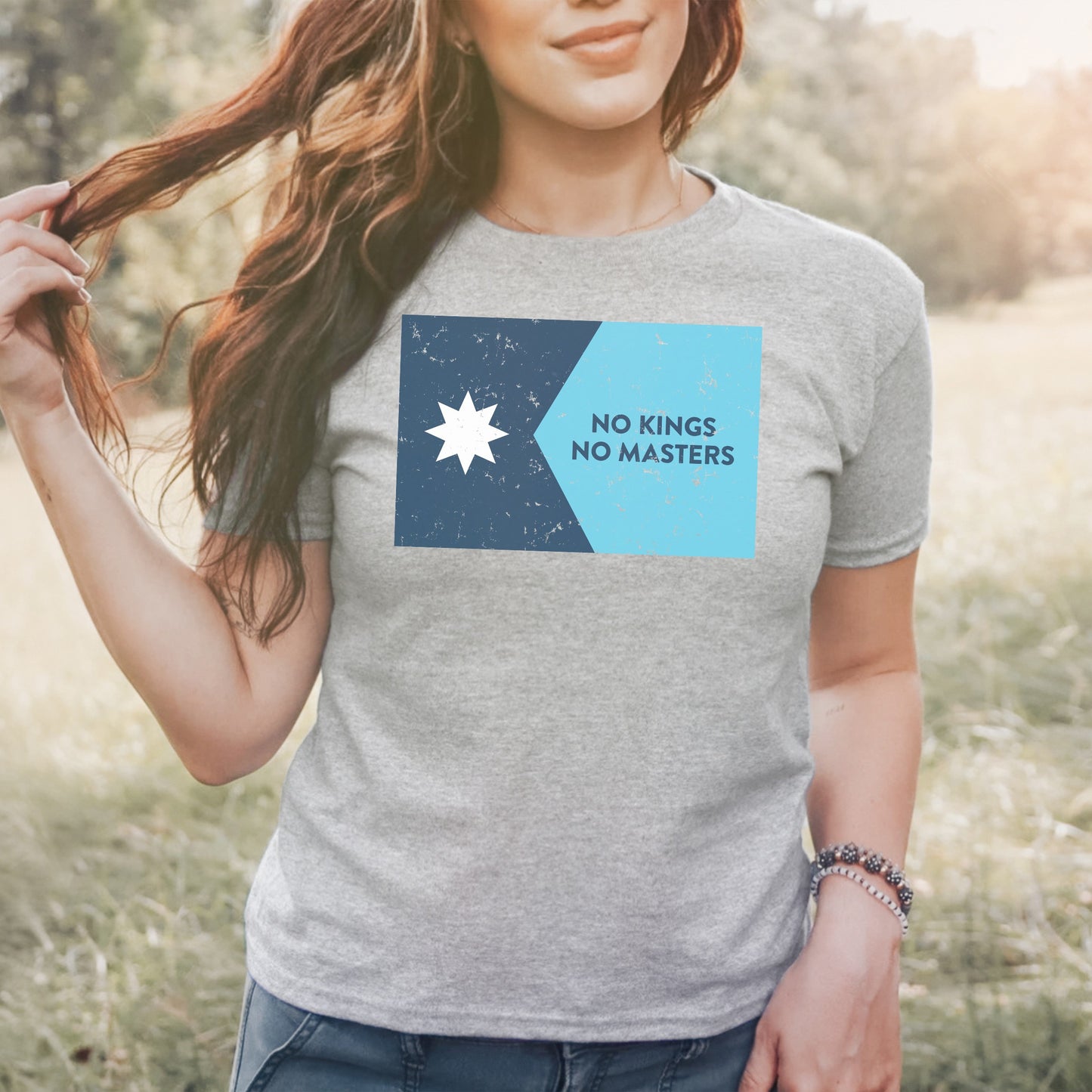 Minnesota No Kings Flag Women's Baby Tee features a two-tone graphic with a star and “NO KINGS NO MASTERS” slogan, embodying a bold, anti-authoritarian message in a stylish cropped design.