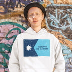 Person in a white hoodie featuring the Minnesota No Kings Flag Shirt design with a two-tone blue graphic, eight-pointed star, and the words NO KINGS NO MASTERS, embodying a spirit of resistance.