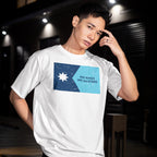 Young man in an urban setting wears a Minnesota No Kings Flag Shirt, featuring a blue star and the phrase NO KINGS NO MASTERS, embodying resistance and freedom.