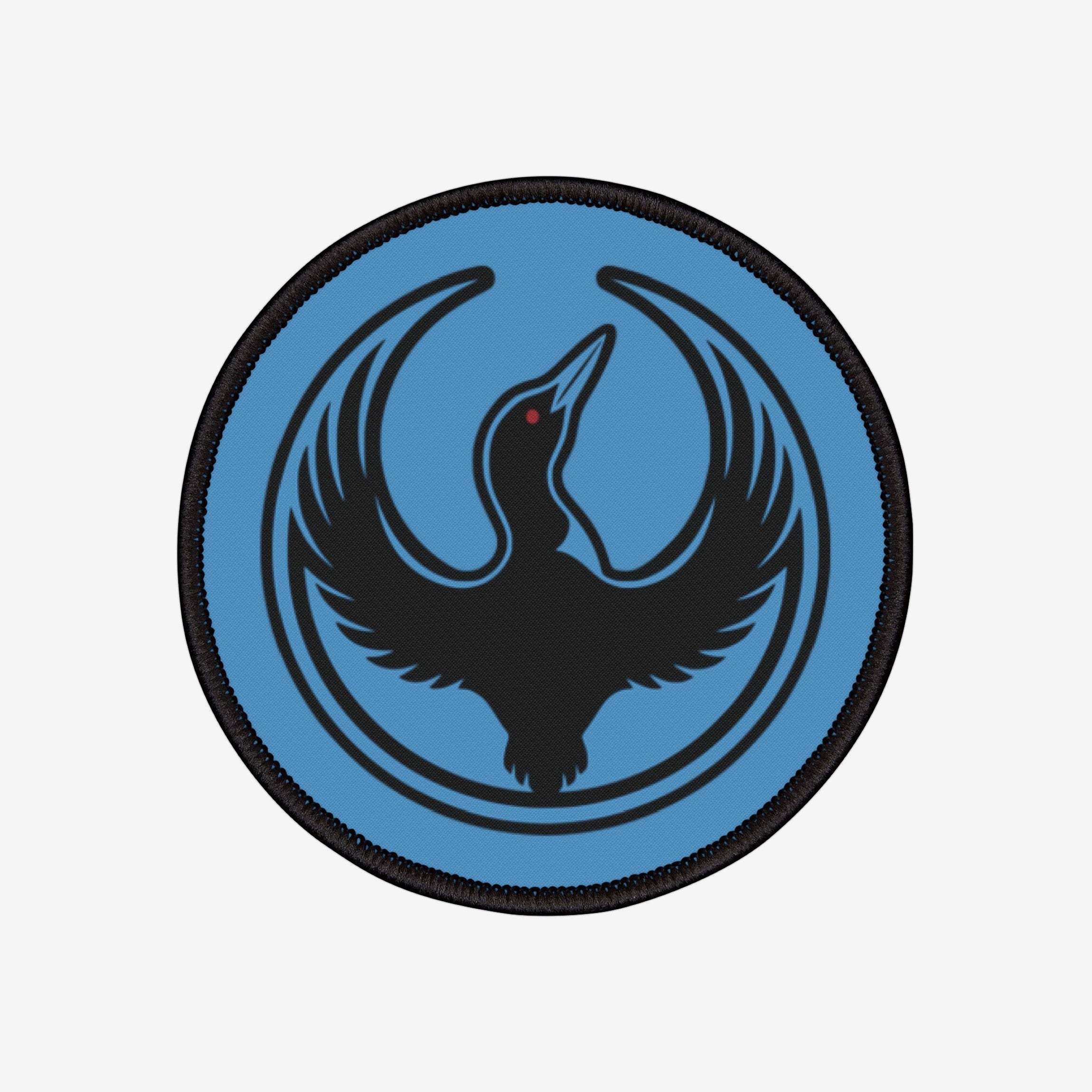 Minnesota Rebel Alliance Patch featuring a stylized black loon with a red eye on a light-blue background, encircled by thin black semicircles, symbolizing resistance and equality.