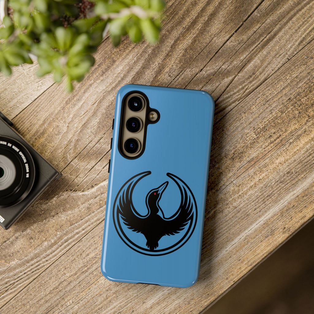 Minnesota Rebel Alliance Samsung Tough Phone Case on a wood tabletop, showcasing a sky-blue cover with a stylized black loon design, symbolizing resistance and equality.