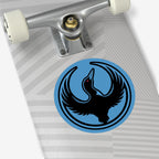 Close-up of a skateboard deck underside featuring a silver “Venture” truck, off-white wheel, and the Minnesota Rebel Alliance Sticker—a blue circle with a black bird, emphasizing anti-fascism and immigrant rights.