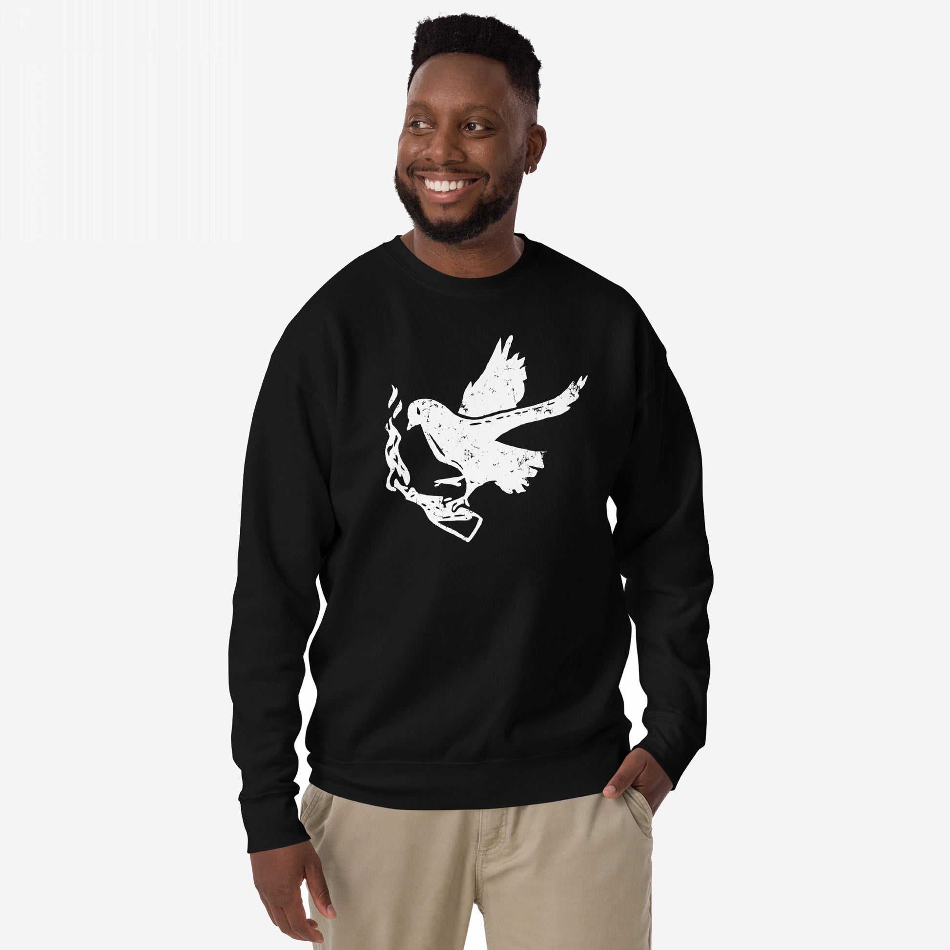 Molotov Messenger Hoodie & Sweatshirt: Man modeling a black crew-neck with distressed white dove graphic clutching a smoking gun, embodying subversive protest spirit and peace through power.