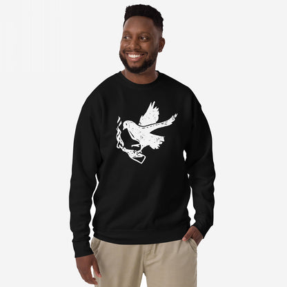 Molotov Messenger Hoodie & Sweatshirt: Man modeling a black crew-neck with distressed white dove graphic clutching a smoking gun, embodying subversive protest spirit and peace through power.