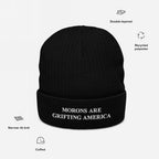 A labeled graphic image of the black anti-MAGA beanie showing its features: narrow rib knit, cuffed fit, double layering, and recycled polyester construction. The embroidered phrase "MORONS ARE GRIFTING AMERICA" is prominently displayed.