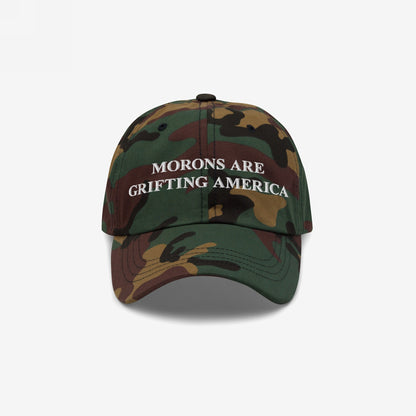Camouflage-print baseball cap with a curved brim, featuring the embroidered message Morons Are Grifting America in white. Ideal for political realists seeking direct, honest expression. Ships from the E.U.