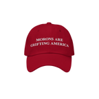 Red dad hat styled to mimic MAGA caps but flipped with embroidered white text "Morons Are Grifting America" — a direct anti