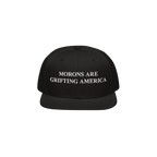 Black snapback hat with flat brim and white embroidered text "Morons Are Grifting America," a bold anti-MAGA message on struc
