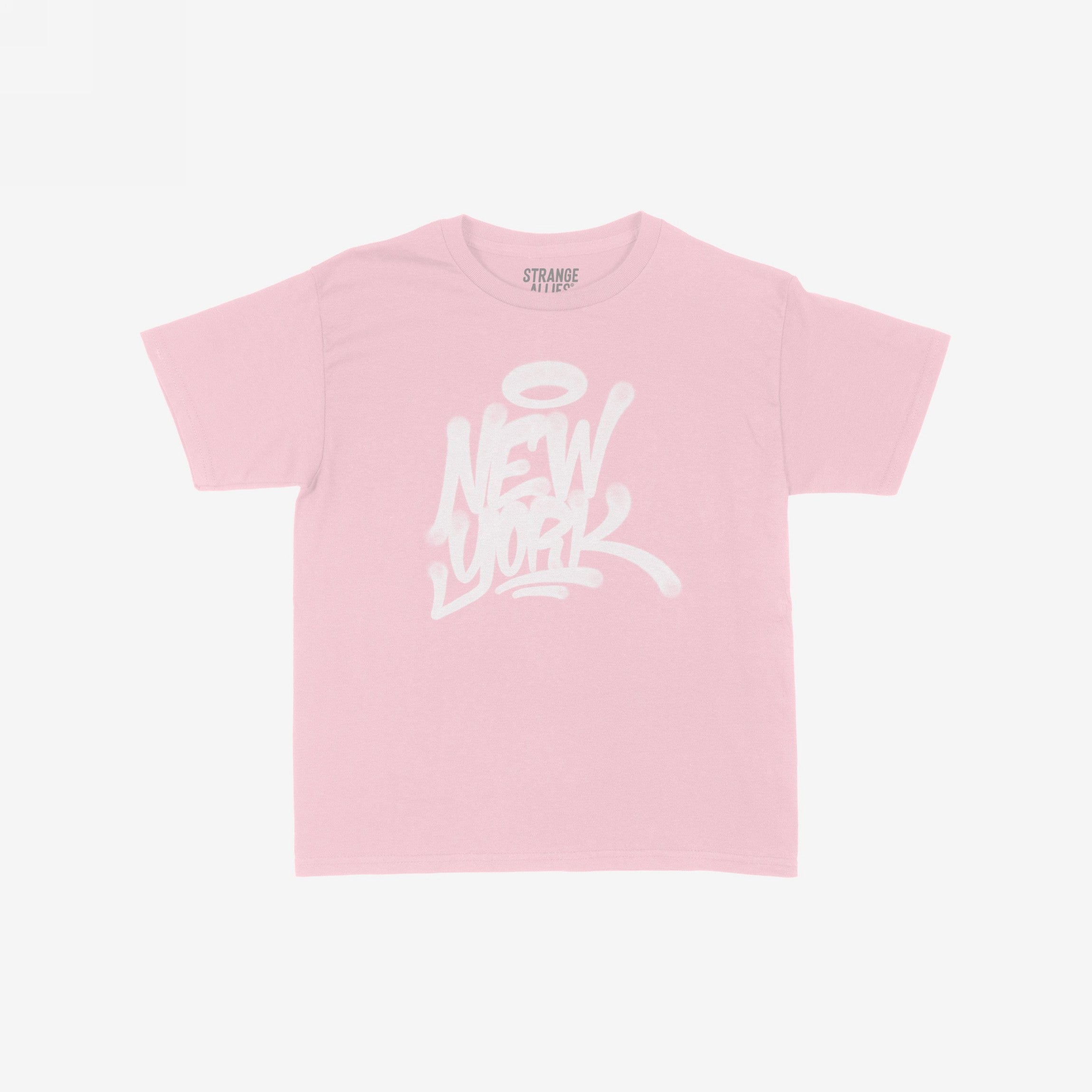 Pale-pink New York Handstyle Women's Baby Tee featuring a white graffiti-style New York graphic with a halo. Designed for a fitted or relaxed look, embodying bold NYC spirit. Label reads “STRANGE ALLIES.”