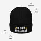 No Kings No Masters Hat: Black cuffed beanie with NO KINGS NO MASTERS white embroidery, yellow chevron accents; features double-layered recycled polyester, narrow rib knit, showcasing a rebellious and anarchistic style.