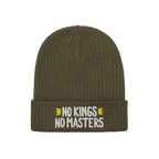The No Kings No Masters Hat is an olive-green, ribbed knit beanie with a folded cuff, featuring white embroidered text flanke