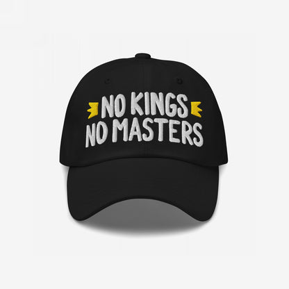 Black cap with bold white NO KINGS NO MASTERS embroidery and yellow crown accents, embodying rebellious spirit. Available in various styles, supporting Amnesty International.