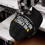 No Kings No Masters Hat in an embroidery machine, featuring white and yellow stitching. The cap's message embodies defiance and individuality, aligning with a bold, anti-establishment ethos.