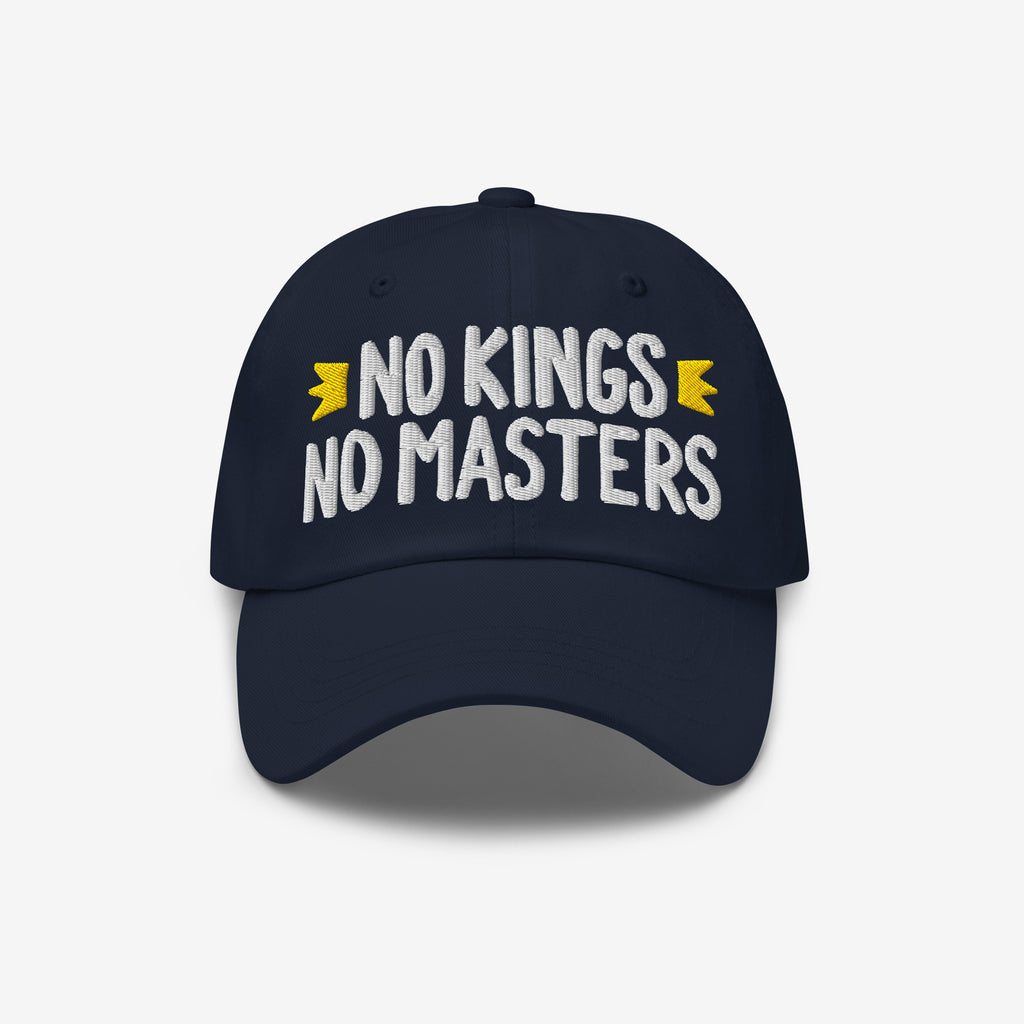 Navy-blue cap with NO KINGS NO MASTERS in white, accented by gold crowns. An anti-establishment statement piece for those who challenge authority and support equality.