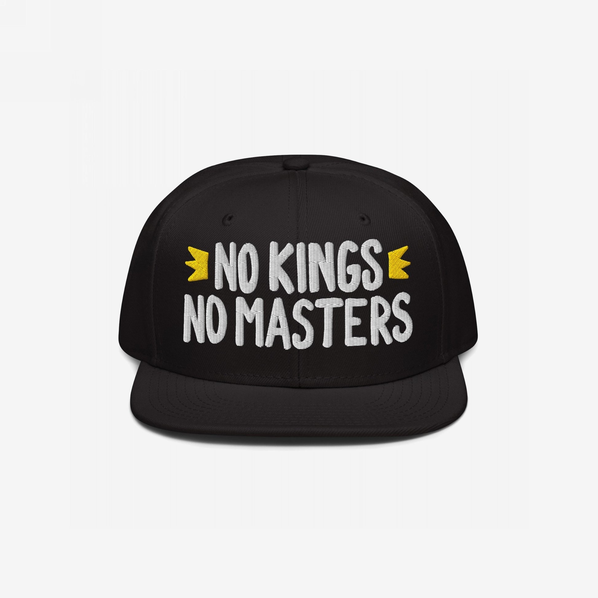 No Kings No Masters Hat features bold white embroidery of the phrase, flanked by yellow crowns, on a black snapback. This rebellious design aligns with a stance against hierarchy and for equality.