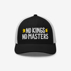 The No Kings No Masters Hat features a black front with white mesh and a curved black brim. Boldly embroidered with “NO KINGS NO MASTERS,” it includes yellow accents, embodying rebellious, anti-authoritarian spirit.
