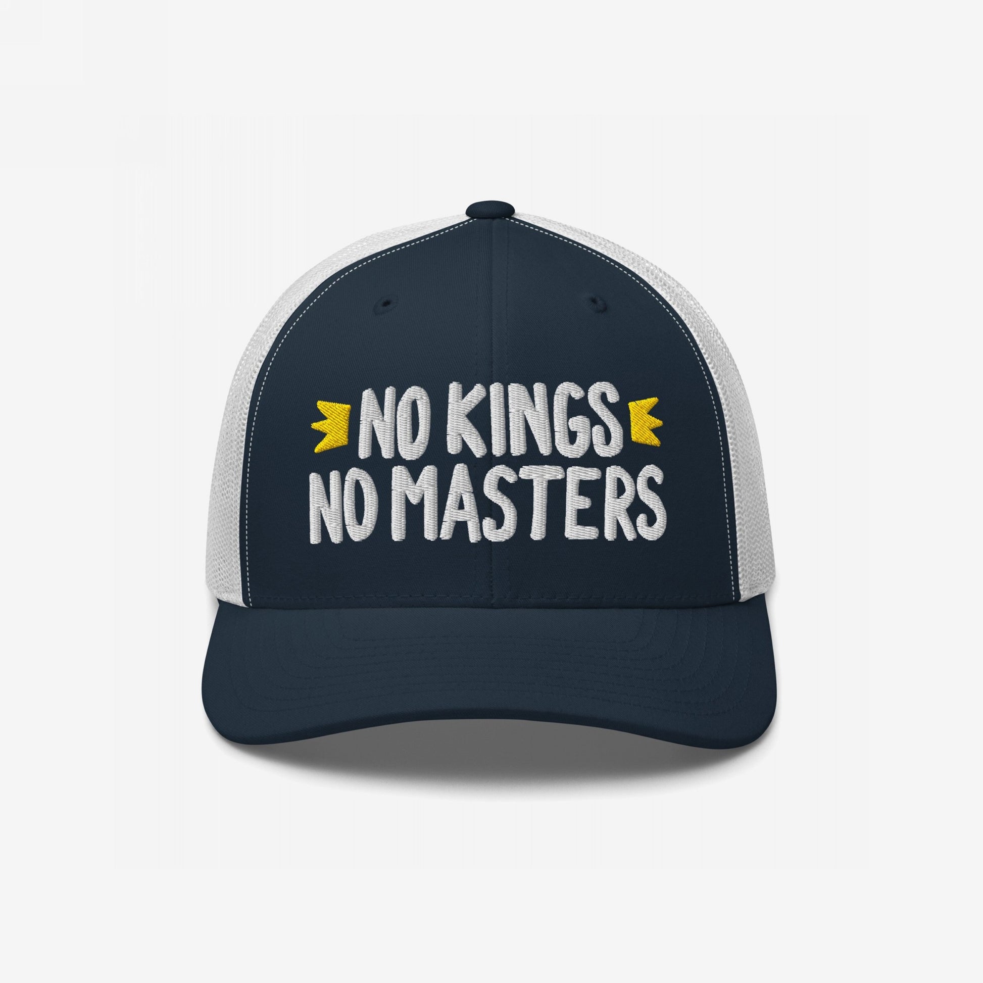 Trucker-style No Kings No Masters hat featuring navy front, white mesh back, and bold white embroidery. The cap embodies rebellion with hand-drawn accents, representing anti-authoritarian style and ethos.