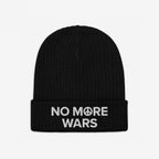 Black rib-knit No More Wars Hat with white embroidered text on the cuff highlighting peace advocacy, featuring a peace symbol, embodying a stance against war and promoting global peace.