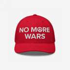 No More Wars Hat with red mesh-back and white embroidered message NO M☮RE WARS, featuring a peace symbol, representing a bold stand for peace against war profiteers.
