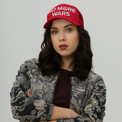 Young woman wearing a No More Wars embroidered cap with a peace symbol, crossing arms, styled in a bomber jacket. This hat boldly conveys an anti-war message, aligning with advocacy for peace and equality.