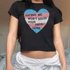 Person wearing the No Trans Hate Women's Baby Tee with a distressed trans pride heart and empowering slogan, showcasing solidarity and resistance against bigotry, paired with a light-colored garment around the hips.