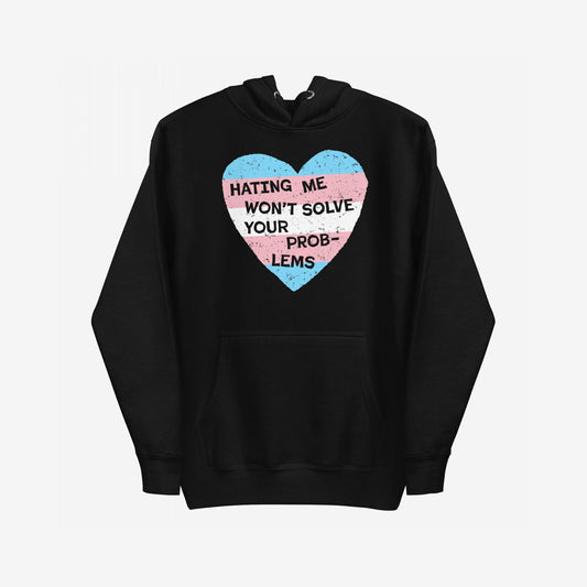 No Trans Hate Hoodie features a black pullover design with a large heart graphic in trans pride colors and the slogan “HATING ME WON’T SOLVE YOUR PROBLEMS,” embodying resilience and solidarity.