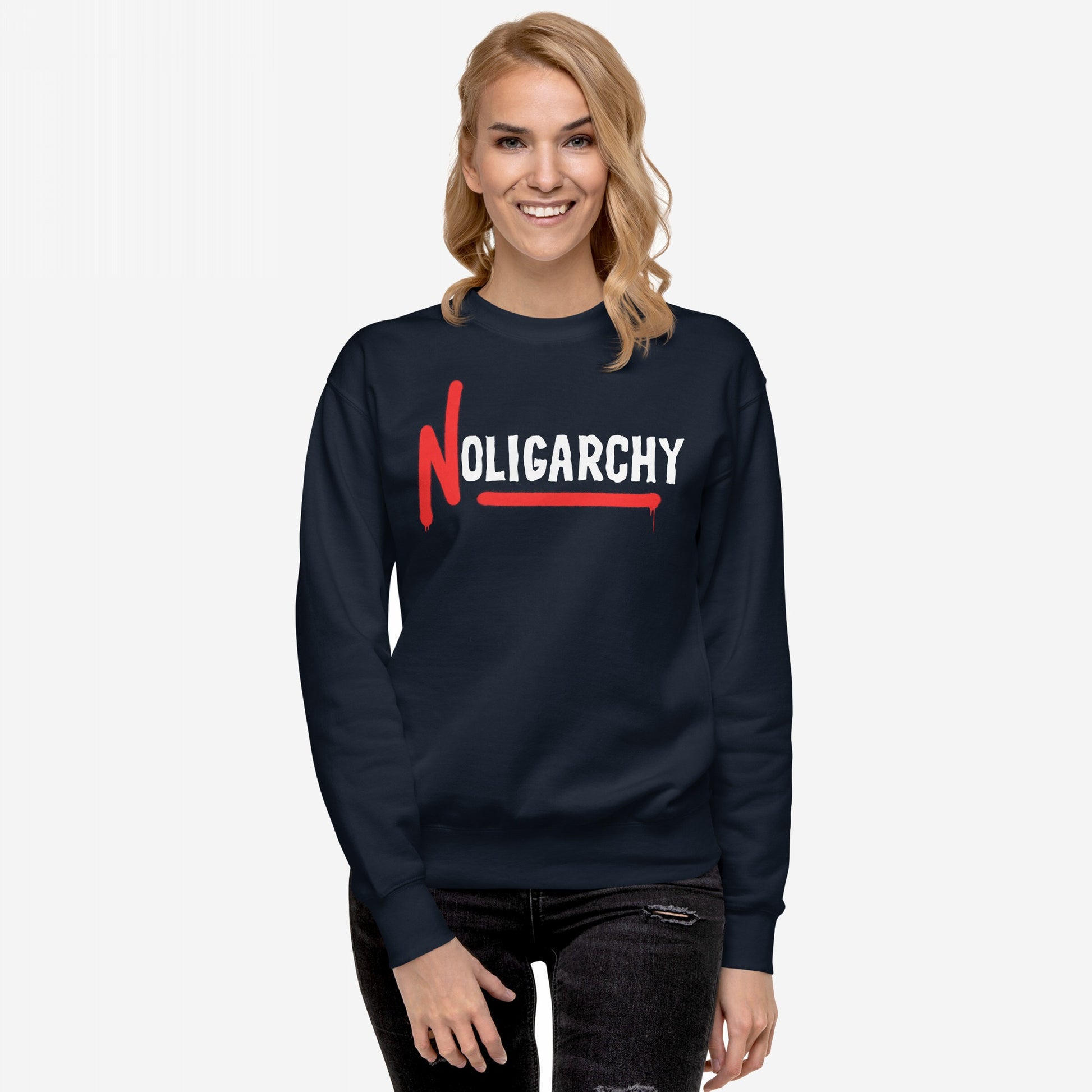 Woman wearing No Oligarchy Hoodie & Sweatshirt with bold white lettering and red paint-drip N, representing rebellion against elite rule, standing against a light background. Perfect for activists and truth-seekers.