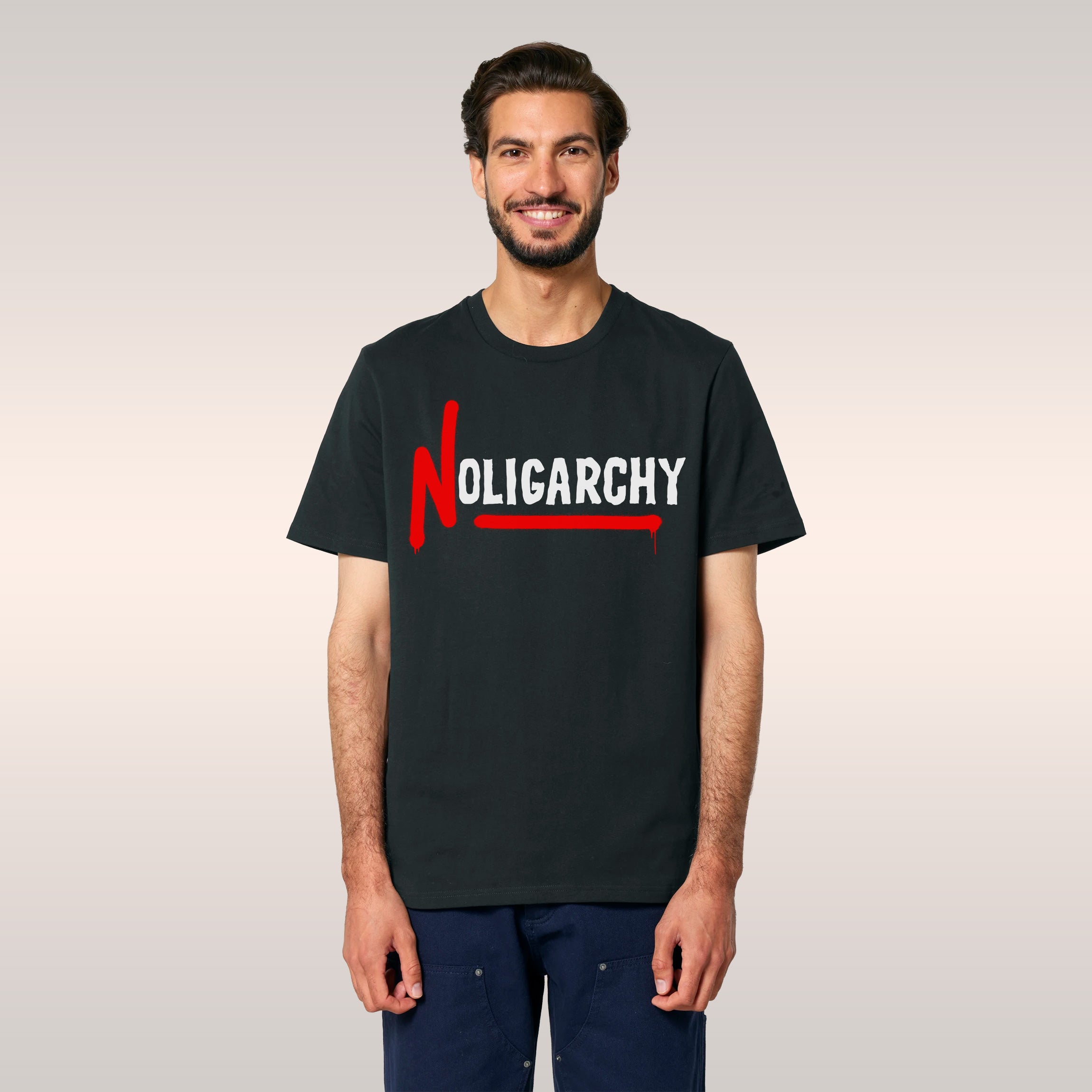 Man wears a No Oligarchy Shirt in an urban setting, featuring bold graffiti-style text. He carries a black bag and a coffee c