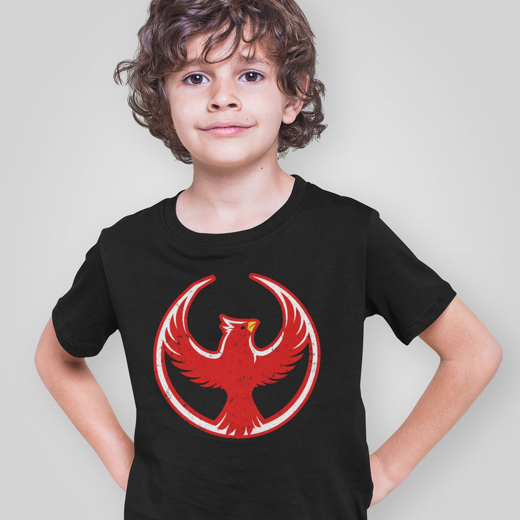 A young child wears the Northern Cardinal Rebel Alliance T-shirt, featuring a stylized red phoenix-like bird inside a circle, representing defiance and solidarity for immigrant rights and equality.