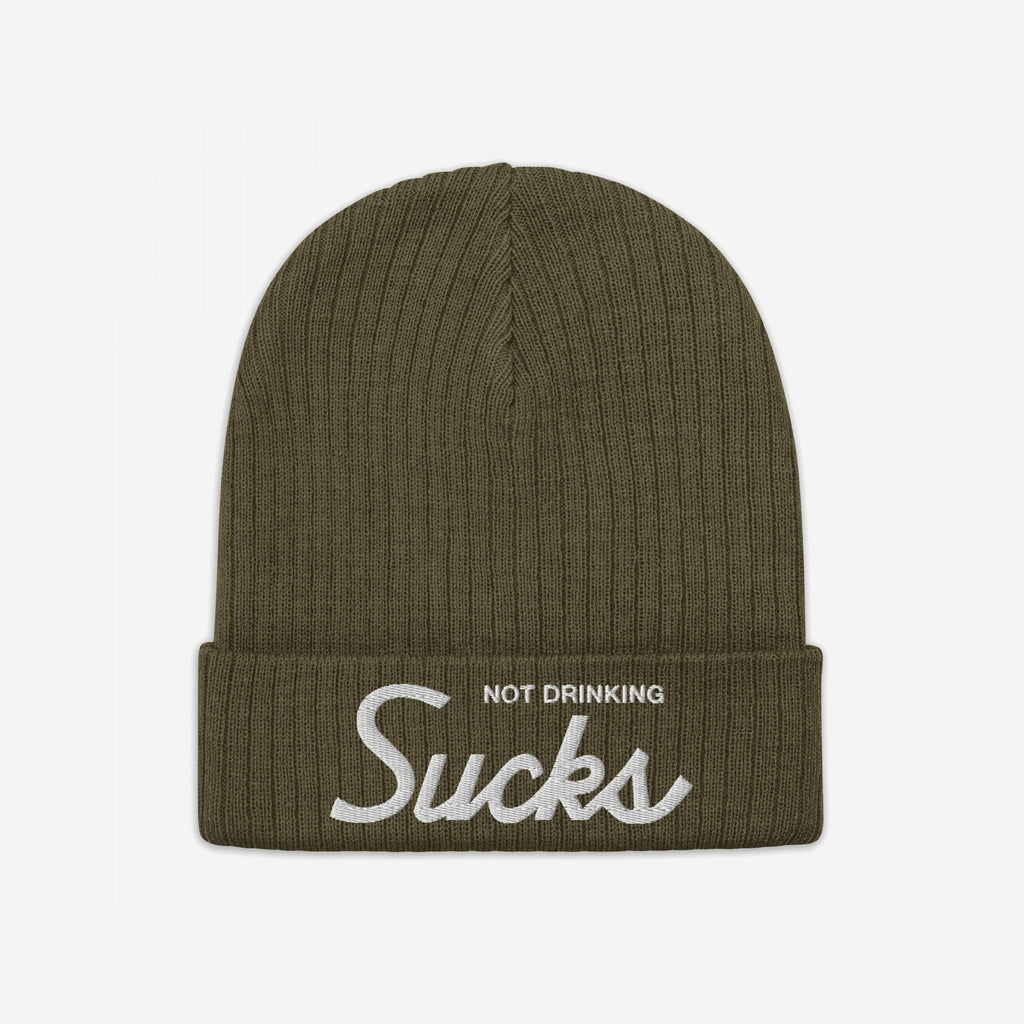 The Not Drinking Sucks Hat is an olive-green rib-knit beanie with a folded cuff, featuring white embroidered text that captures a playful, bold attitude perfect for any casual outing.