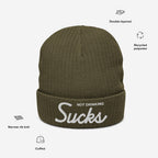 Olive-green Not Drinking Sucks Hat in rib-knit design, featuring bold white embroidery on the cuff; crafted from recycled polyester, capturing a playful and bold attitude, perfect for social gatherings.