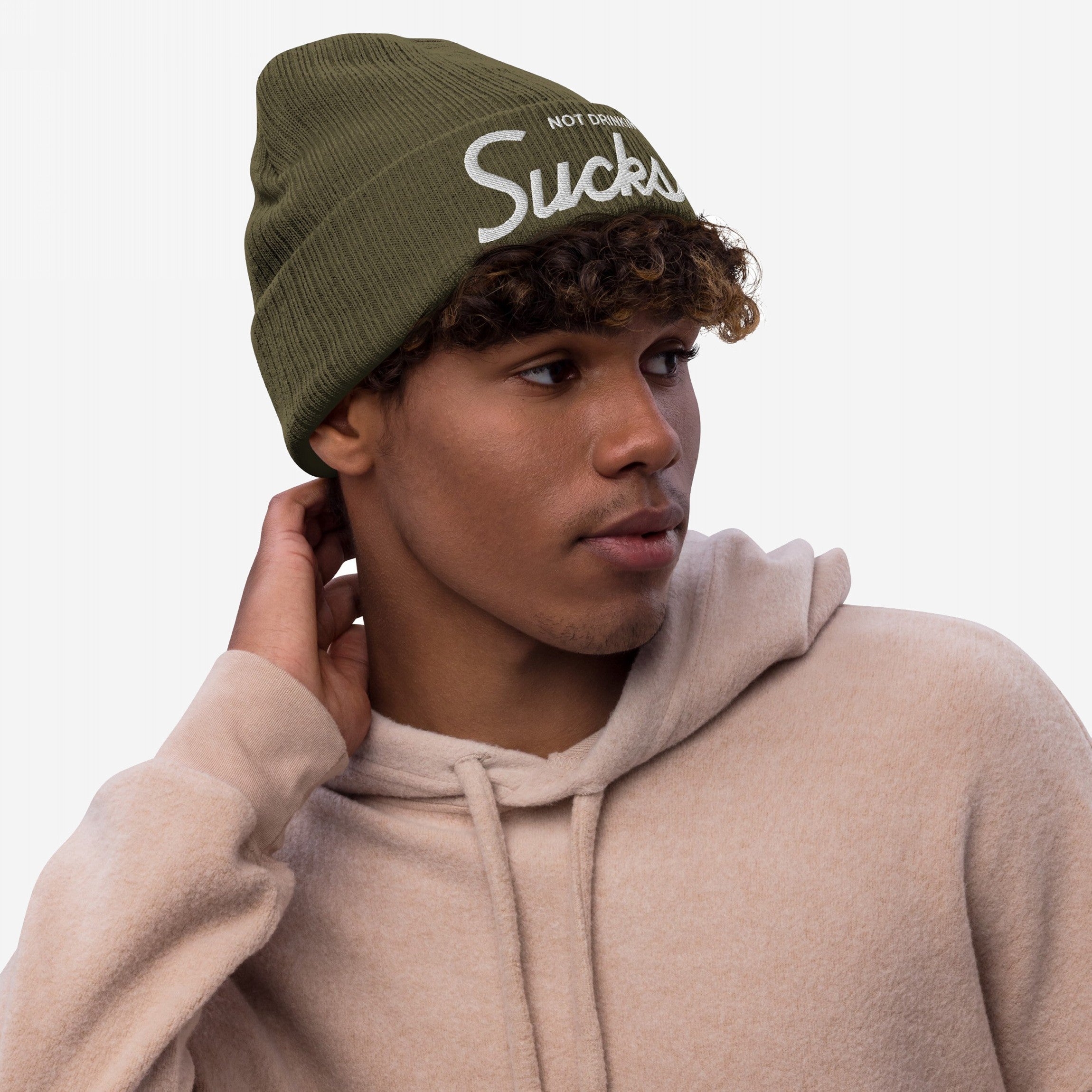 Young man wearing a Not Drinking Sucks knit beanie, featuring white embroidered text, capturing a bold, playful vibe perfect for expressing a carefree, social attitude.