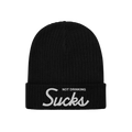 Black rib-knit beanie with Not Drinking Sucks embroidered on the cuff, capturing a bold, playful vibe. Reflects an unapologet
