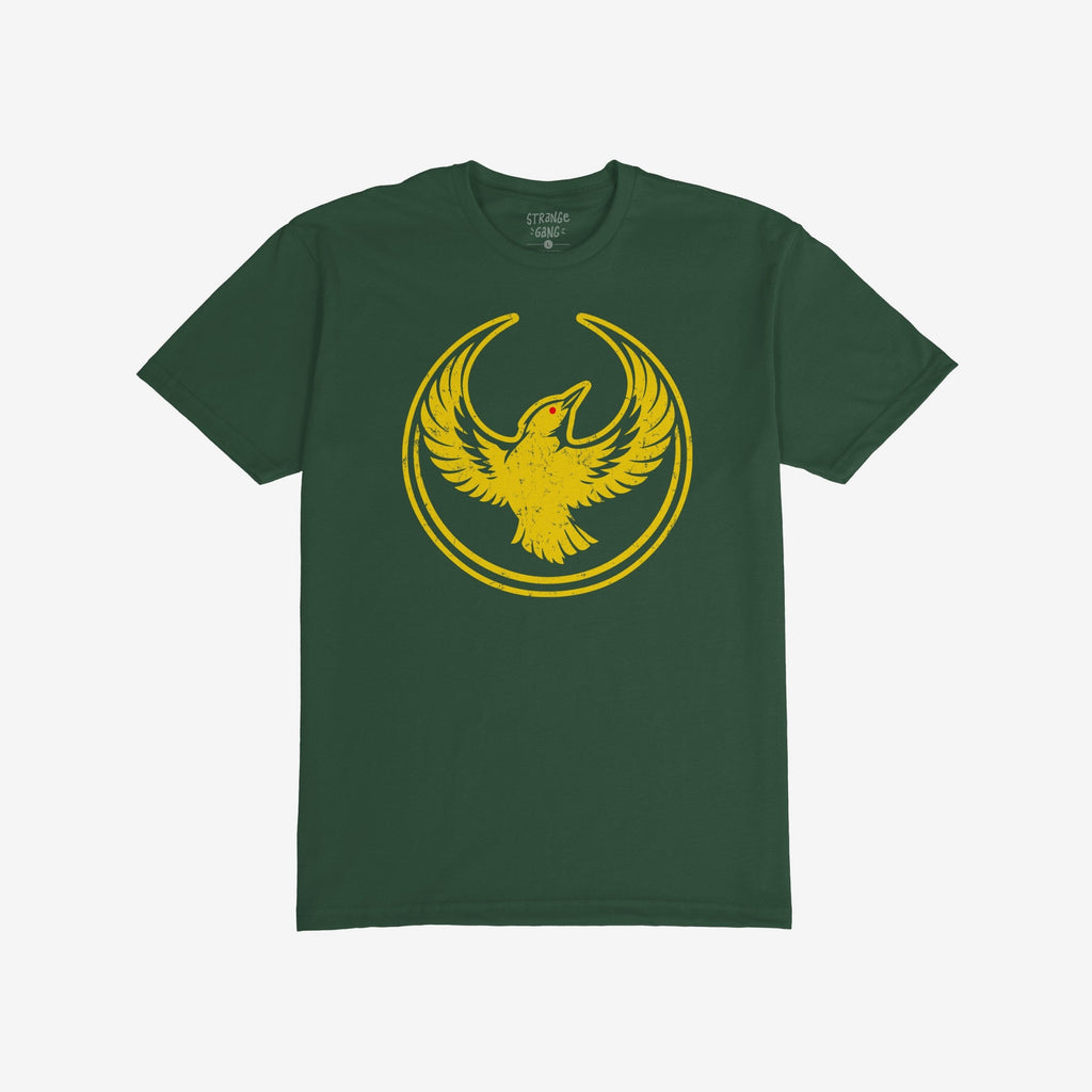 Forest-green Oregon Rebel Alliance T-shirt with a circular, distressed emblem featuring a stylized golden-yellow bird, highlighted eye, symbolizing protest and support for equality and immigrant rights.