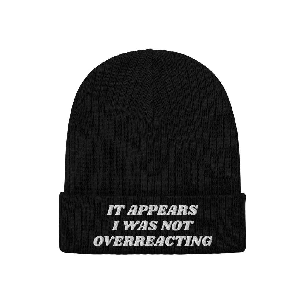 Black rib-knit beanie titled Overreacting Hat, featuring white embroidery on the cuff with the phrase “IT APPEARS I WAS NOT