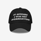 Black Overreacting Hat with white embroidered text, IT APPEARS I WAS NOT OVERREACTING, signifies anti-fascist sentiment. Ideal for progressive activism, available in various styles, supporting ACLU initiatives.