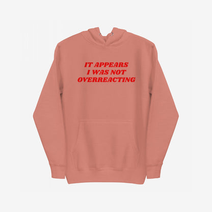 Overreacting Hoodie & Sweatshirt with bold red text, IT APPEARS I WAS NOT OVERREACTING, centered on soft fleece. Features a kangaroo pocket and drawstring hood, embodying unapologetic resistance against oppressive systems.