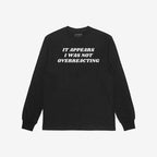 The Overreacting Shirt, a black long-sleeve crewneck, features bold white lettering stating It appears I was not overreacting, highlighting a powerful anti-fascist message. Brand visible inside the collar.