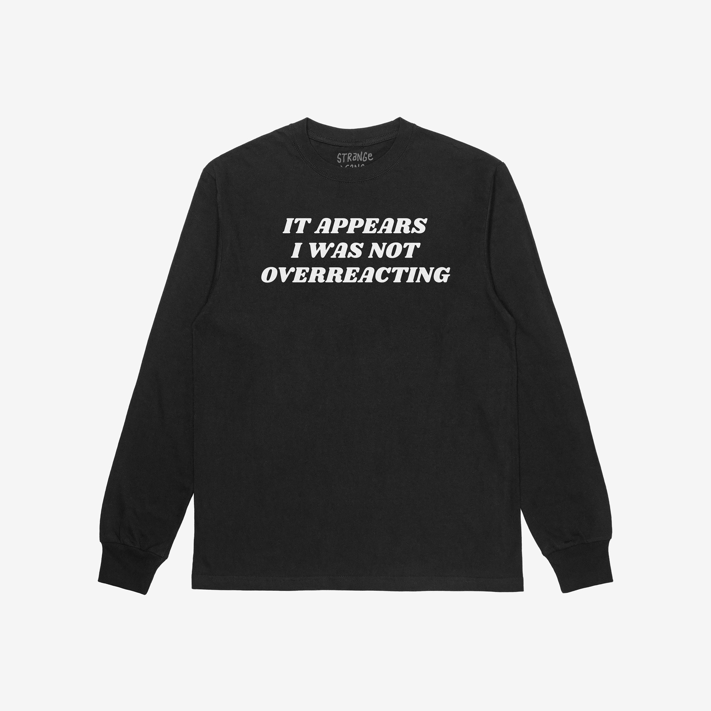 The Overreacting Shirt, a black long-sleeve crewneck, features bold white lettering stating It appears I was not overreacting, highlighting a powerful anti-fascist message. Brand visible inside the collar.